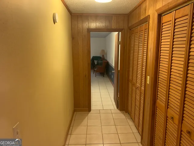 a hallway with a wooden floor and a bathroom
