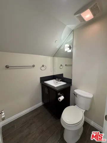 a bathroom with a granite countertop toilet and a mirror