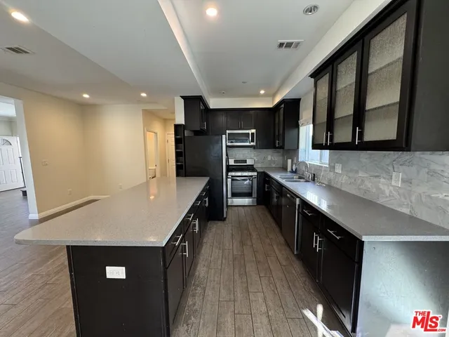 a kitchen with stainless steel appliances a stove a sink a refrigerator and a oven