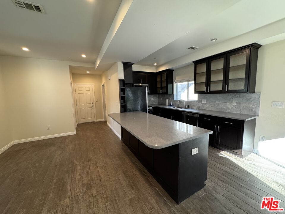 24842 Frampton Avenue Harbor City, CA 90710 - Photo 24 of 26 a kitchen with stainless steel appliances granite countertop a sink a stove and a wooden floors