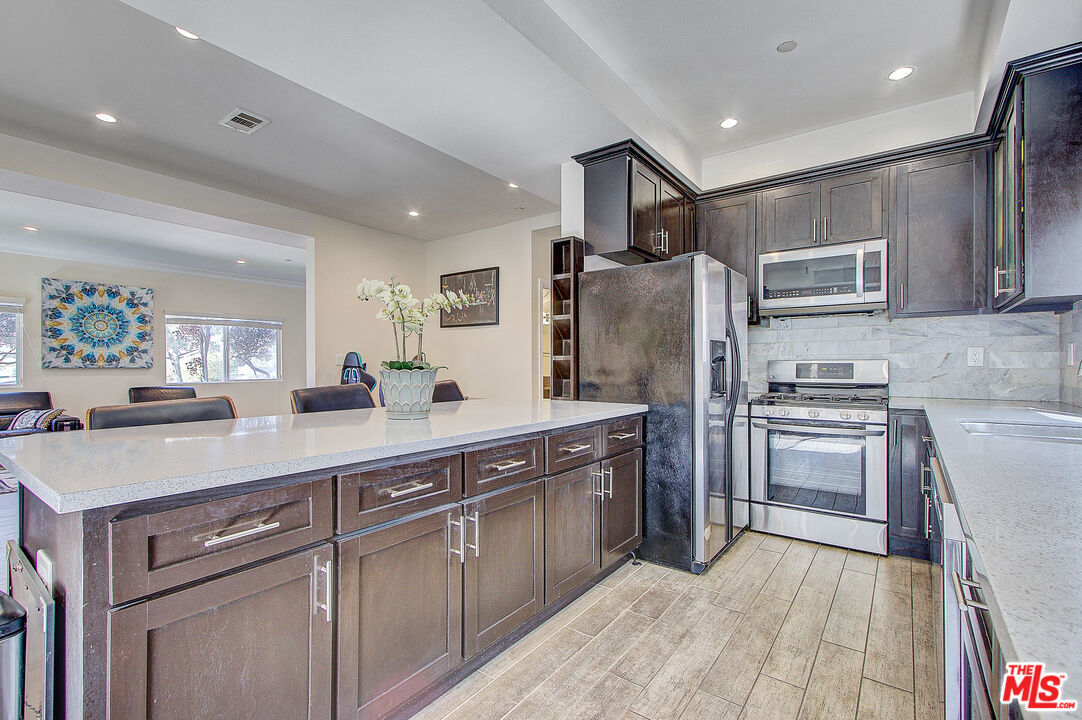 24842 Frampton Avenue Harbor City, CA 90710 - Photo 9 of 26 a kitchen with stainless steel appliances granite countertop a refrigerator and a stove top oven