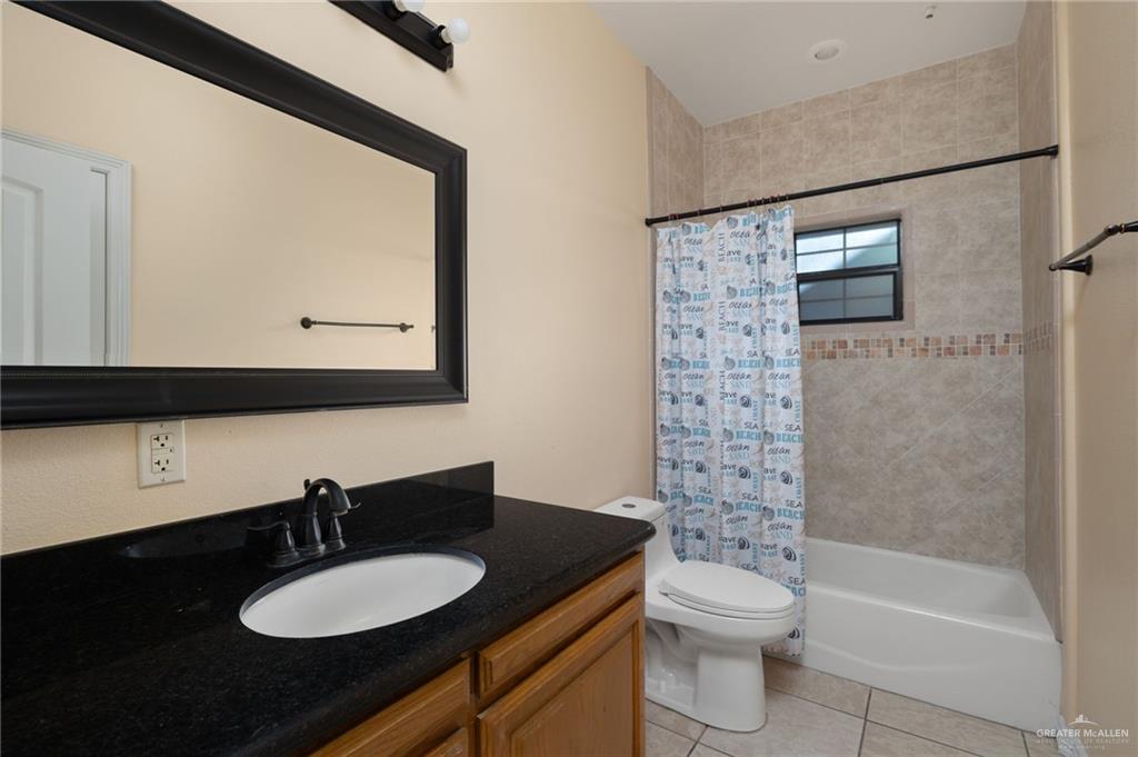 504 Orchard Court Weslaco, TX 78596 - Photo 15 of 24 a bathroom with a granite countertop sink toilet a mirror and bathtub