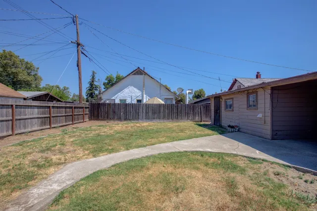 a view of a backyard with wooden fence
