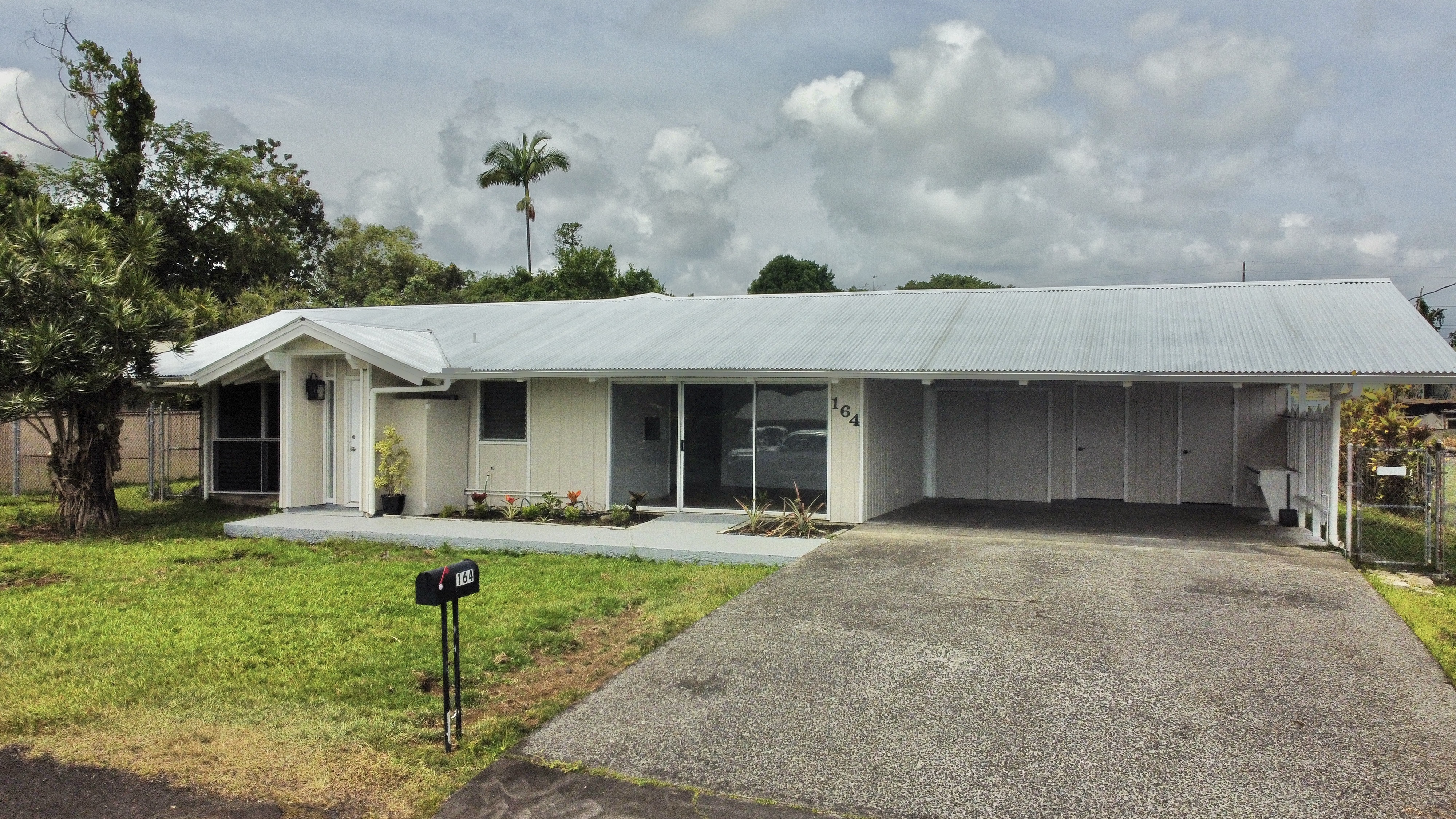 164 Likeke Street Hilo, HI 96720 - Photo 2 of 29 a front view of a house with a yard and garage