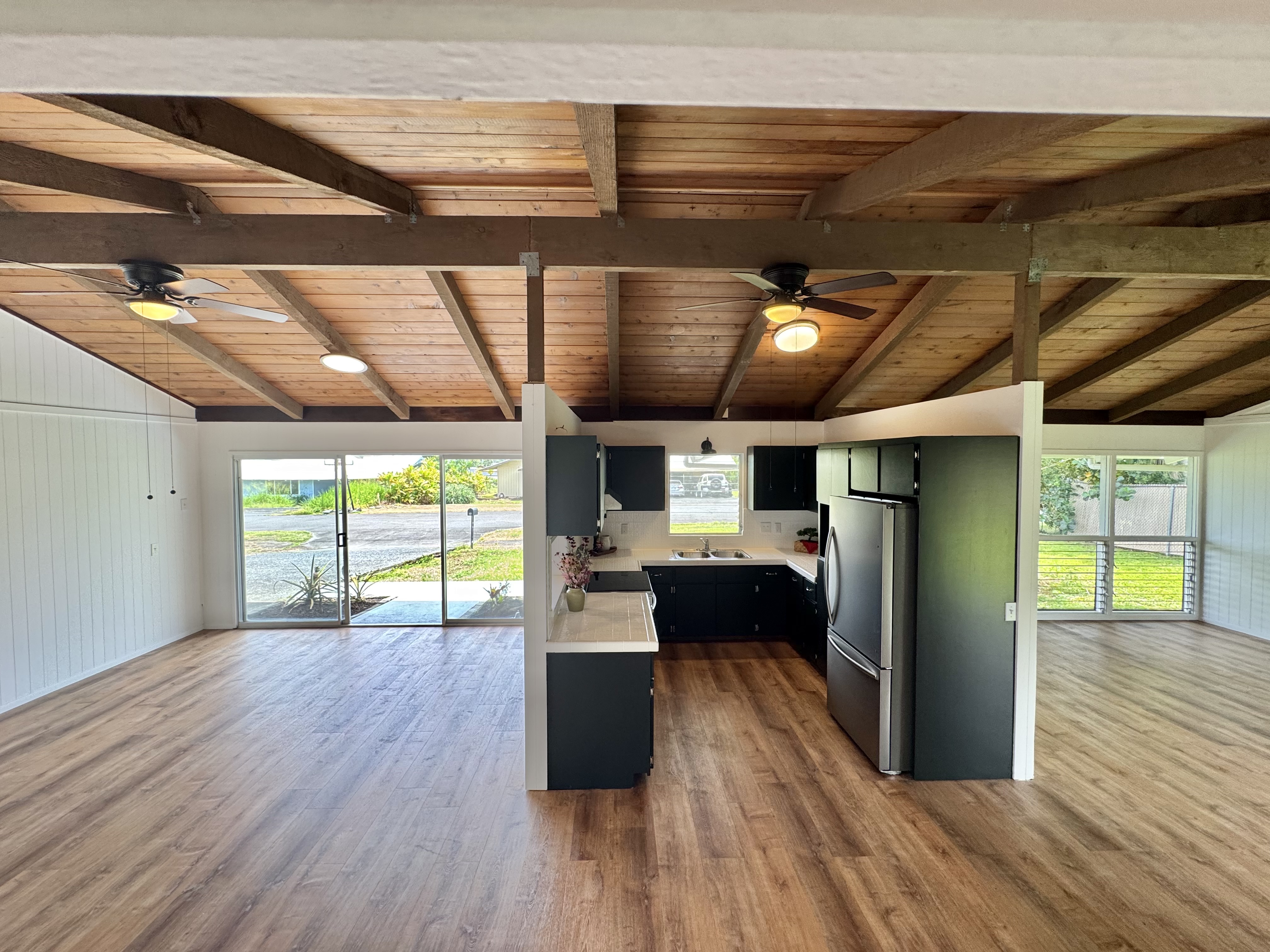 164 Likeke Street Hilo, HI 96720 - Photo 6 of 29 a view of a room with wooden floor a ceiling fan and a window