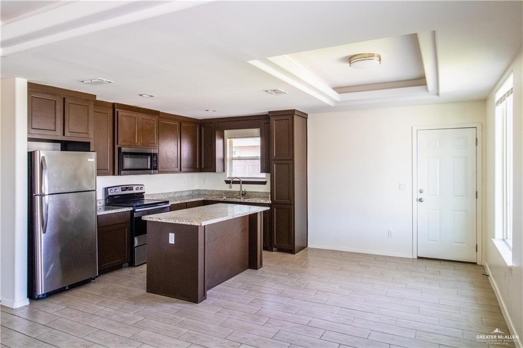 2118 Taxco Court, Unit 2 Edinburg, TX 78542 - Photo 3 of 13 a kitchen with stainless steel appliances granite countertop a stove a refrigerator and a sink