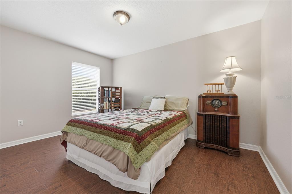 23152 Northwest 11th Road Newberry, FL 32669 - Photo 20 of 31 a bedroom with a bed and a lamp