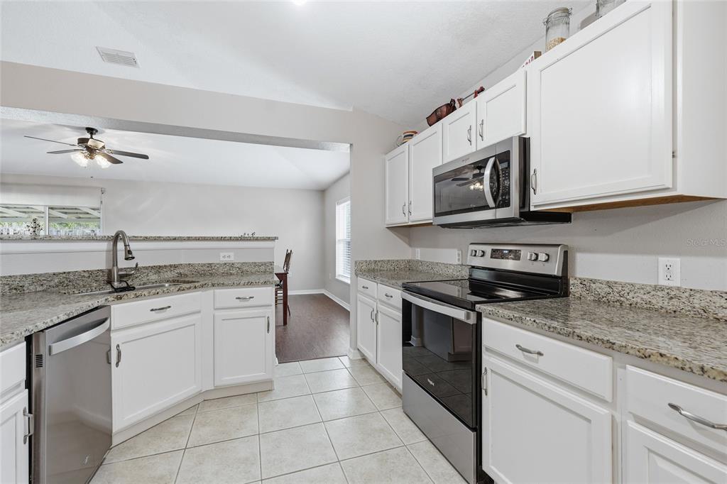 23152 Northwest 11th Road Newberry, FL 32669 - Photo 9 of 31 a kitchen with stainless steel appliances granite countertop a stove sink and cabinets