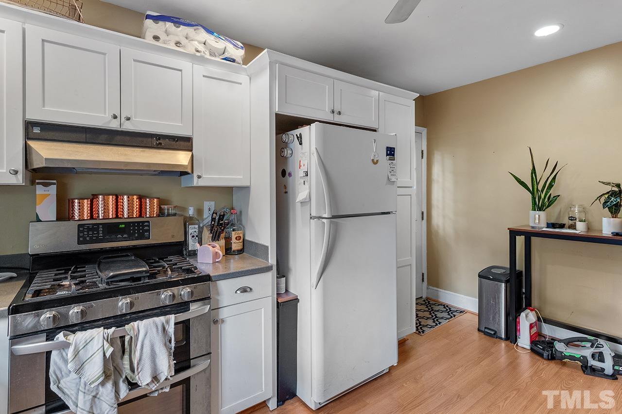 324 Cutler Street Raleigh, NC 27603 - Photo 13 of 34 a kitchen with stainless steel appliances a refrigerator a stove a sink cabinets and a wooden floor