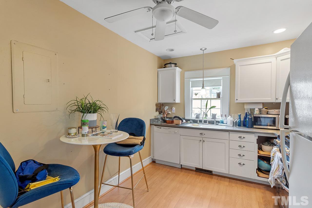 324 Cutler Street Raleigh, NC 27603 - Photo 14 of 34 a kitchen with stainless steel appliances kitchen island granite countertop a table chairs in it and white cabinets