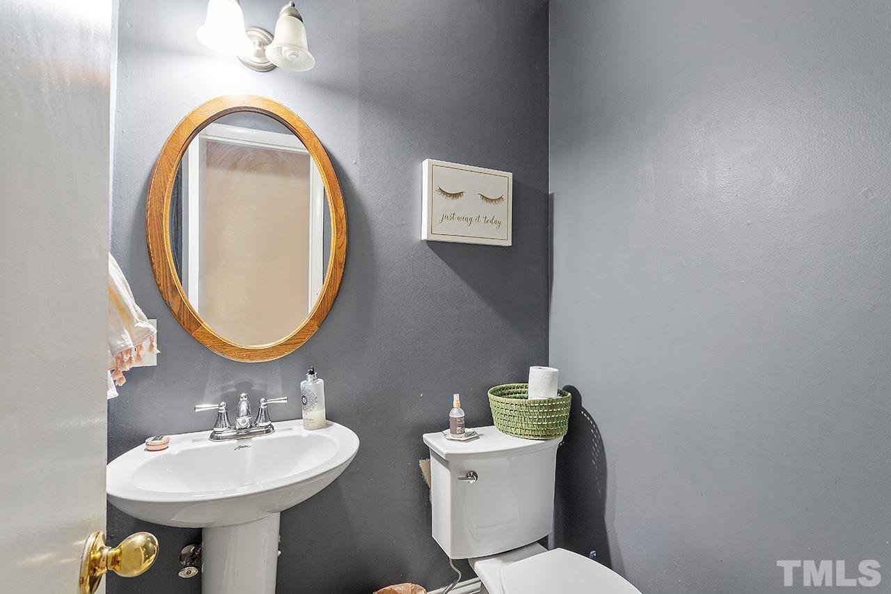 324 Cutler Street Raleigh, NC 27603 - Photo 9 of 34 a bathroom with a toilet a sink and a mirror