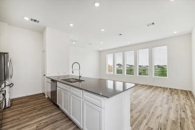 a kitchen with a sink and wooden floor