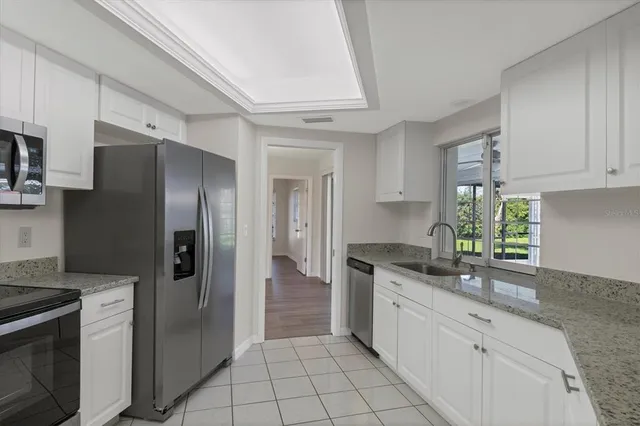 a kitchen with stainless steel appliances granite countertop a refrigerator and a stove
