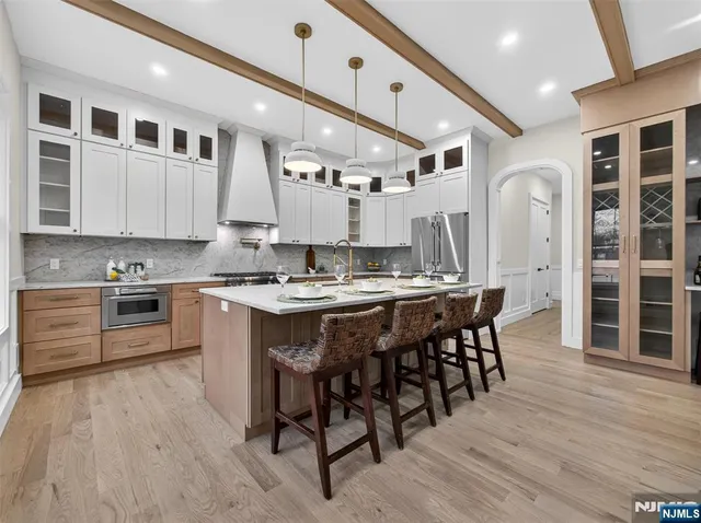 a kitchen with granite countertop a stove a sink a dining table and chairs