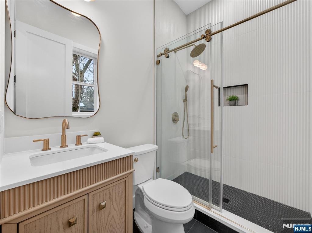 61 Beech Street Ramsey, NJ 07446 - Photo 17 of 41 a bathroom with a sink a toilet and shower