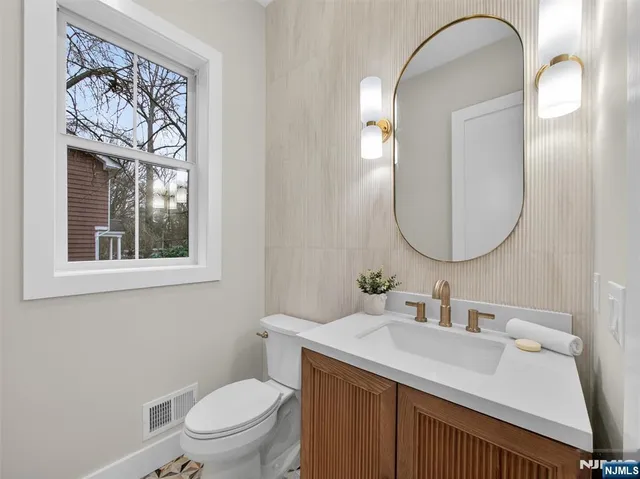 a bathroom with a toilet a sink and mirror