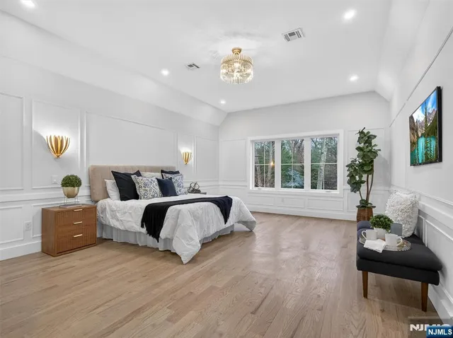 a spacious bedroom with a bed and glass window
