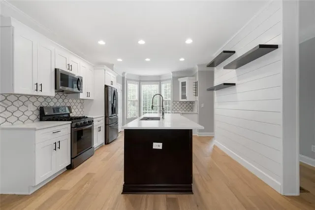 a kitchen with stainless steel appliances granite countertop a stove a sink and a refrigerator