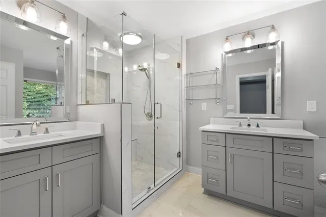 a bathroom with a double vanity sink mirror and next to a window