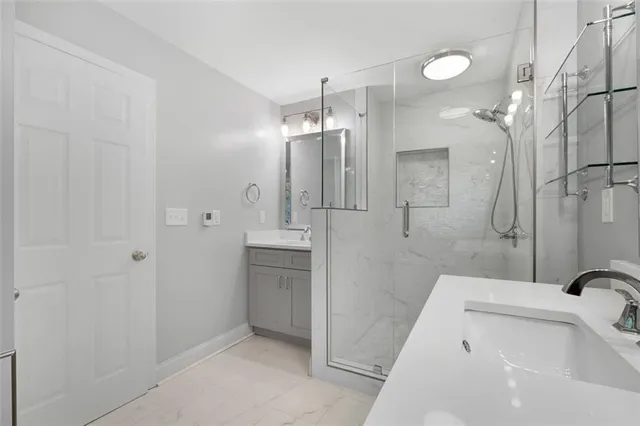 a bathroom with a tub a sink and glass door shower