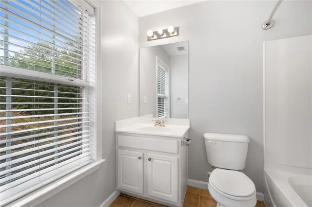 a front view of a house with a yard and potted plants