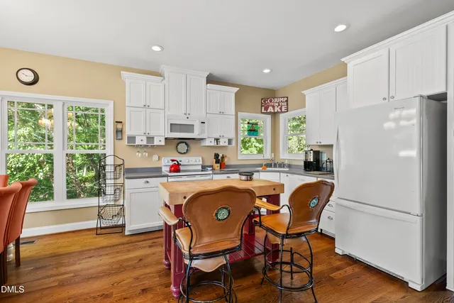 a kitchen with a table chairs sink and cabinets