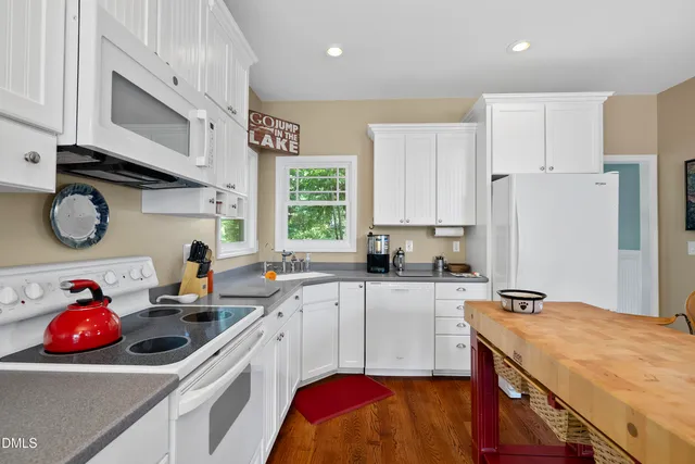 a kitchen with a table chairs refrigerator and microwave