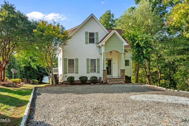 an aerial view of residential house with outdoor space and trees all around