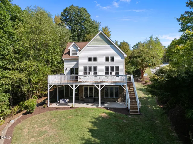 a view of a yard with plants and large trees
