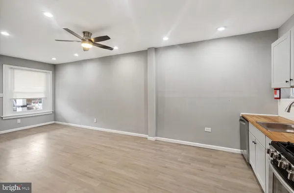 an empty room with windows and fan