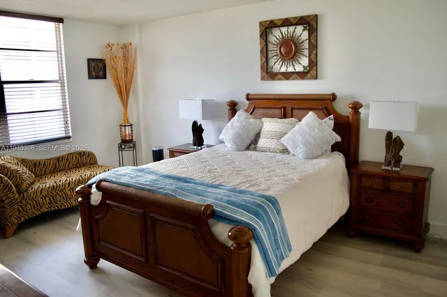 a bedroom with bed and wooden floor