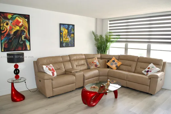 a living room with furniture kitchen and window