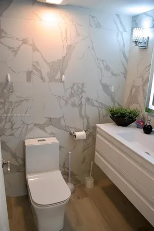 a white toilet sitting next to a shower