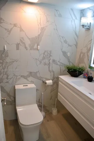 a white toilet sitting next to a shower
