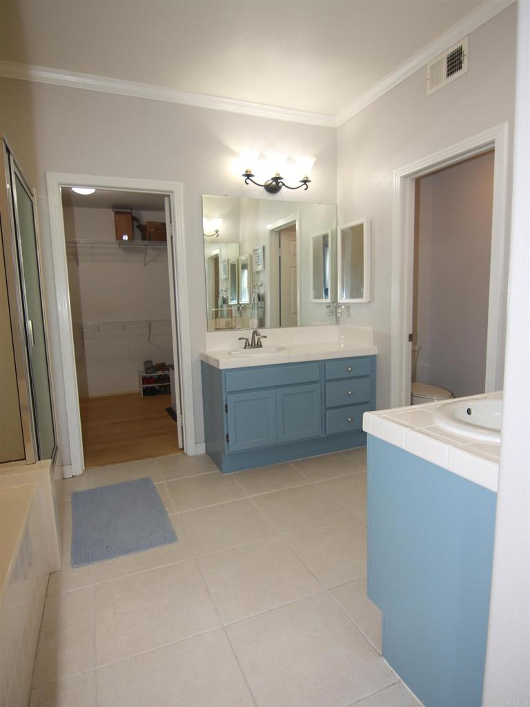 445 Poets Square Fallbrook, CA 92028 - Photo 19 of 37 a bathroom with a tub sink shower and mirror