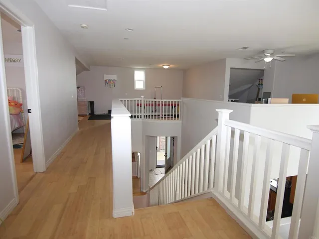 a view of a hallway with wooden floor and stairs
