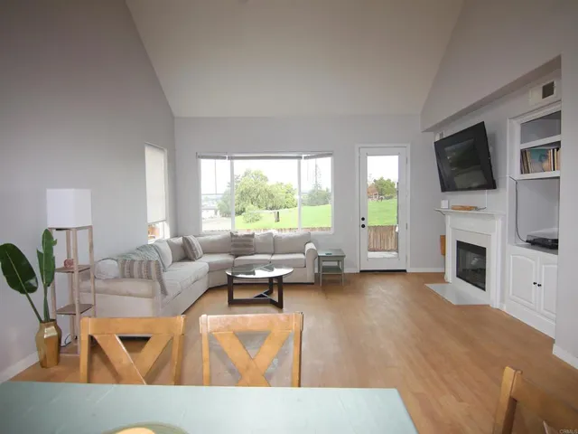 a living room with furniture a fireplace and a flat screen tv