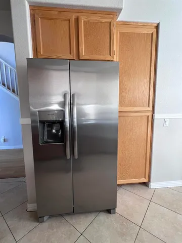 a metallic refrigerator freezer sitting in a kitchen