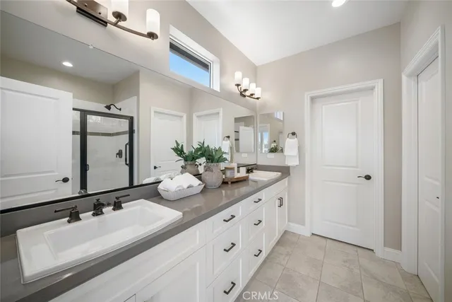 a bathroom with double vanity sinks and a mirror