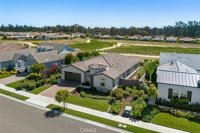 an aerial view of a house with a garden and lake view