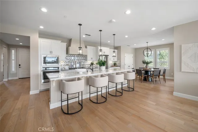 a kitchen with lots of counter and chairs