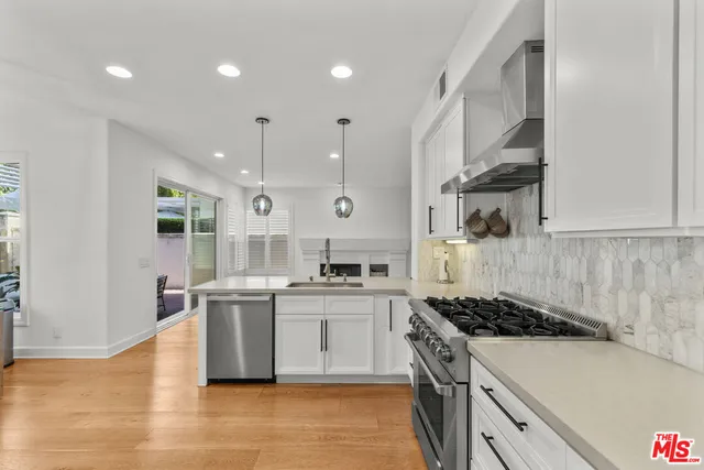 a large kitchen with stainless steel appliances granite countertop a stove and a sink