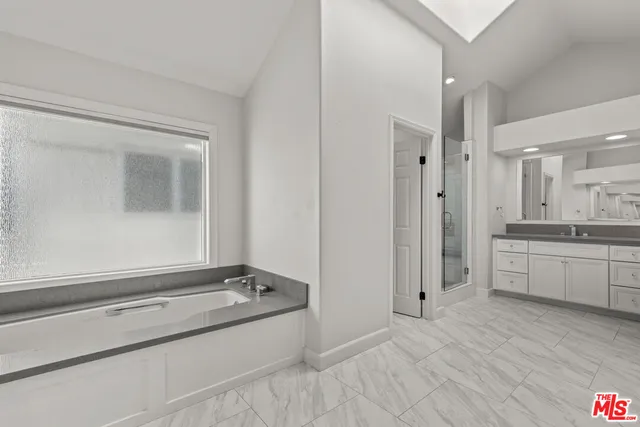 a bathroom with a tub sink and mirror