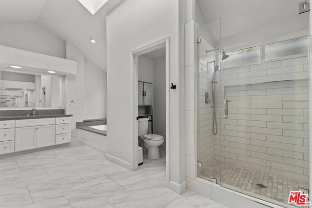 a bathroom with a granite countertop toilet a sink and shower