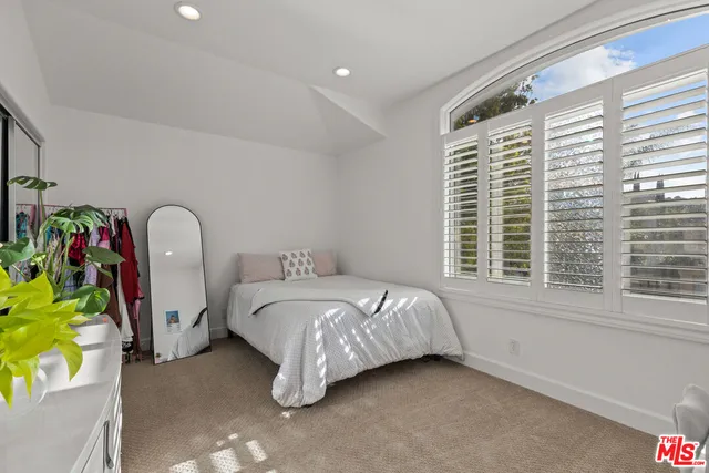 a bed sitting in a bedroom next to a window