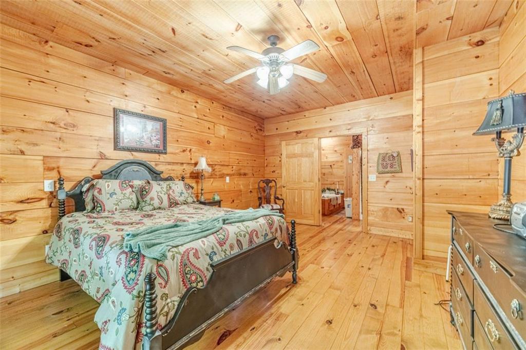 2970 Sky Lake Road Sautee Nacoochee, GA 30571 - Photo 18 of 53 a spacious bedroom with a bed and a chandelier