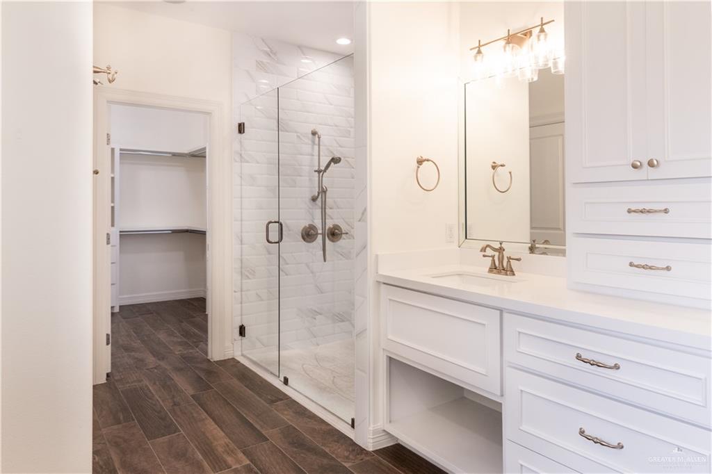 2701 Thompson Street Mission, TX 78573 - Photo 11 of 23 Full bath featuring vanity, a shower stall, wood finish floors, and a walk in closet