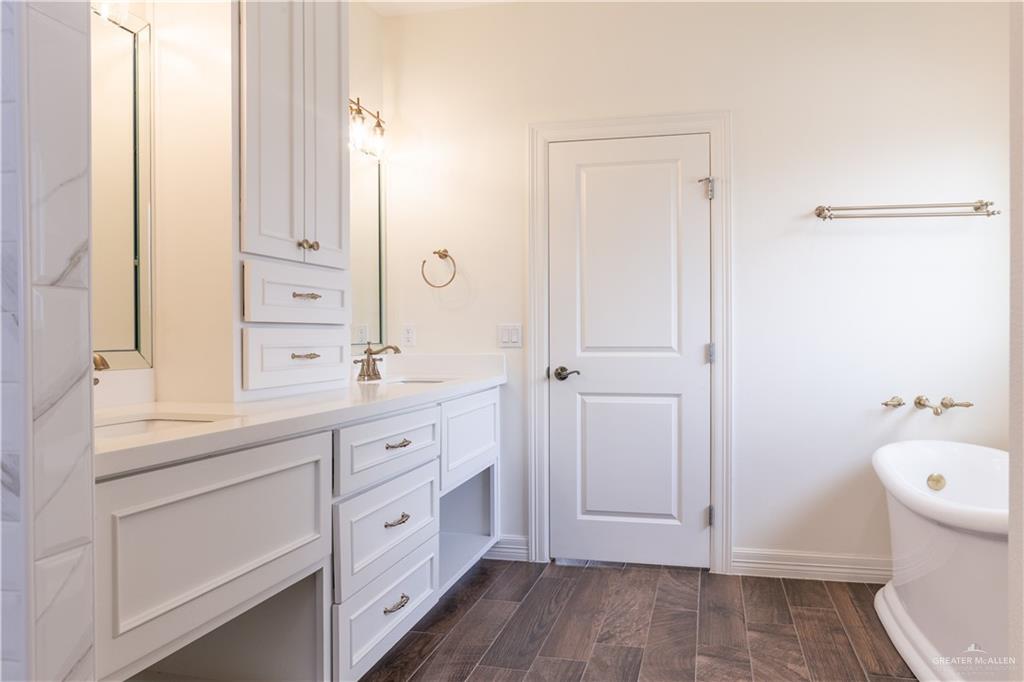 2701 Thompson Street Mission, TX 78573 - Photo 10 of 23 Full bath featuring double vanity, a freestanding bath, and wood finish floors