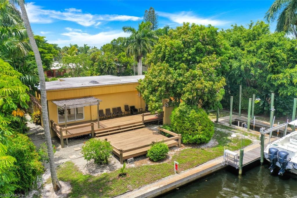 635 15th Avenue South Naples, FL 34102 - Photo 6 of 13 a view of swimming pool with lawn chairs plants and large trees