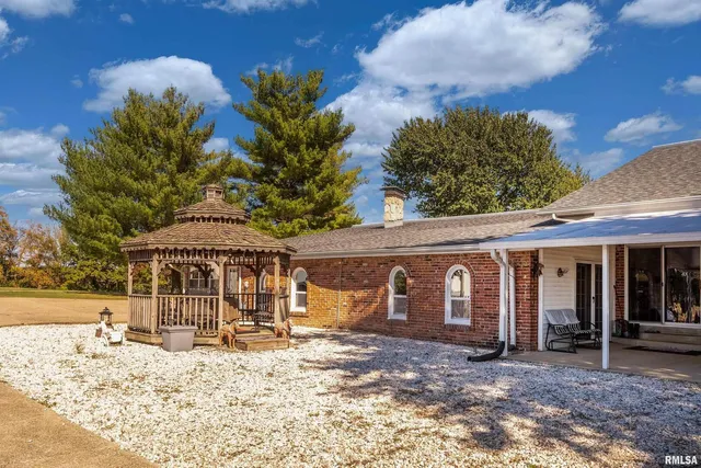 a view of a house next to a big yard with large trees
